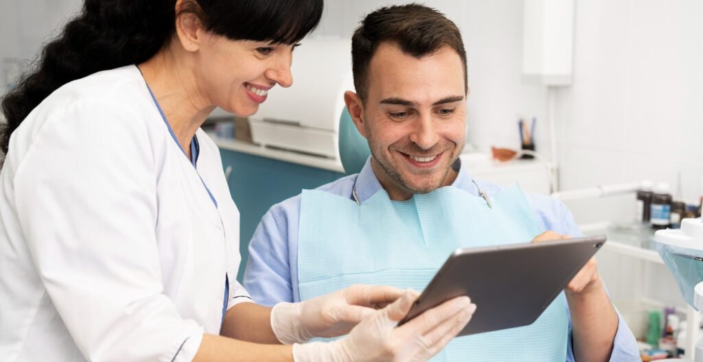 Patient viewing digital veneer simulation on tablet with dentist.